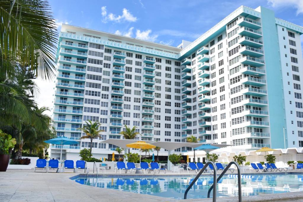 迈阿密海滩迈阿密海滩海岸套房公寓式酒店的一座大型建筑,前面设有一个游泳池