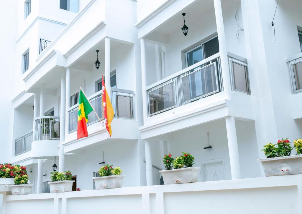 达喀尔J PAD的白色的公寓楼,窗户上悬挂着两个旗帜