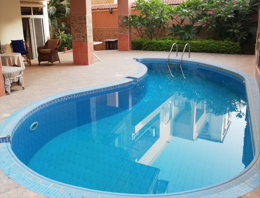开罗Magic Studio Pool View, New Cairo的度假村内的一个蓝色海水游泳池