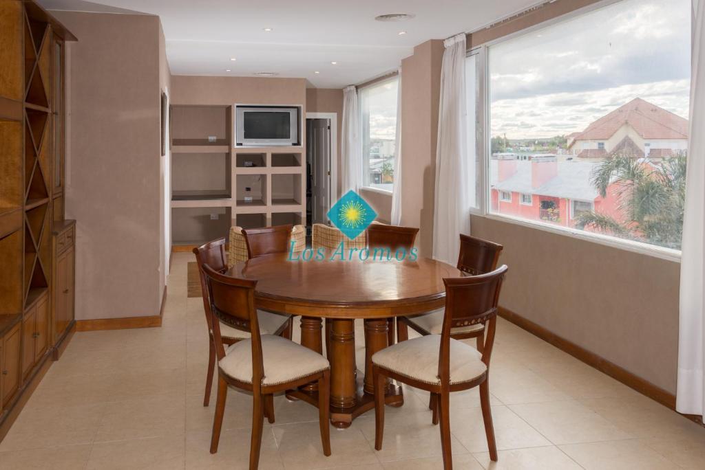 拉斯格路塔斯Los Aromos Apart Spa的一间带桌椅和窗户的用餐室