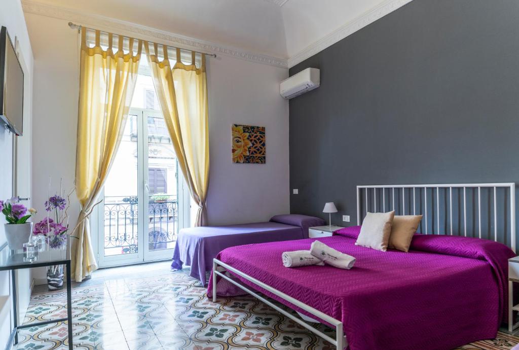 巴勒莫塞拉乌纳沃尔特住宿加早餐旅馆的紫色卧室设有两张床和一扇窗户