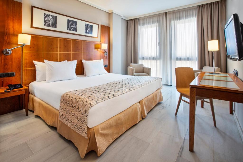 科尔多瓦科尔多瓦埃克斯赛达迪酒店的酒店客房设有一张大床和一张书桌。