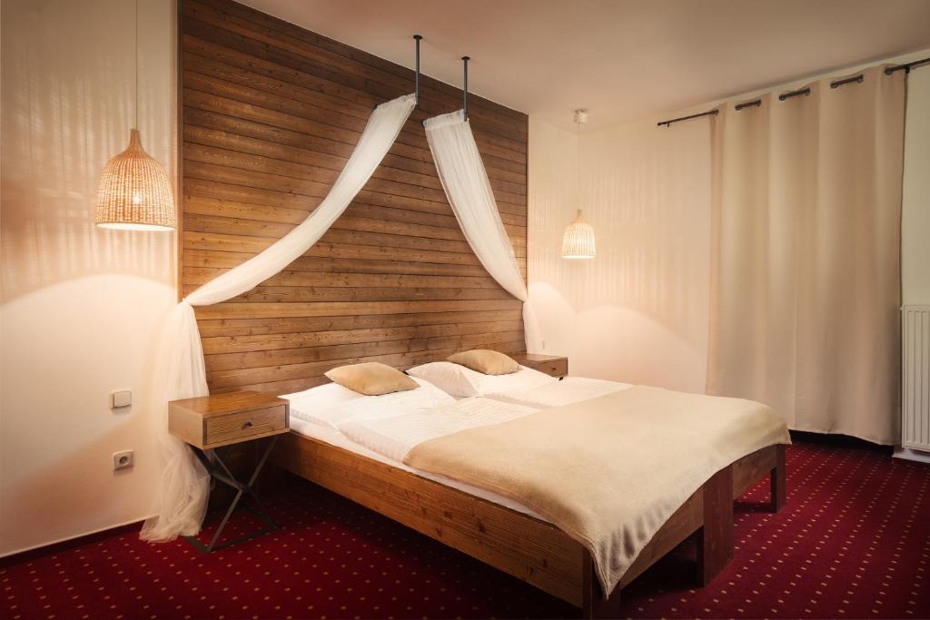 布尔诺萨瑞格哈姆酒店的一间卧室配有一张大床和木制床头板