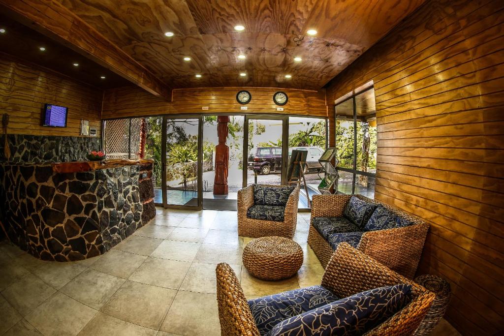 安加罗阿复活节岛生态旅馆 的一间带木墙和椅子的客厅和一间酒吧