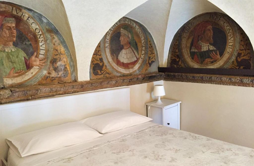 贝加莫Bramantesco的卧室配有三幅壁画和一张床