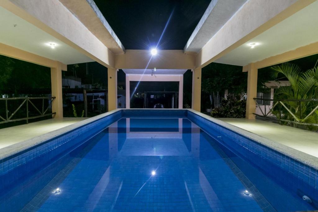 科苏梅尔Casa Hacienda San Gabriel的夜间在房子里的一个游泳池