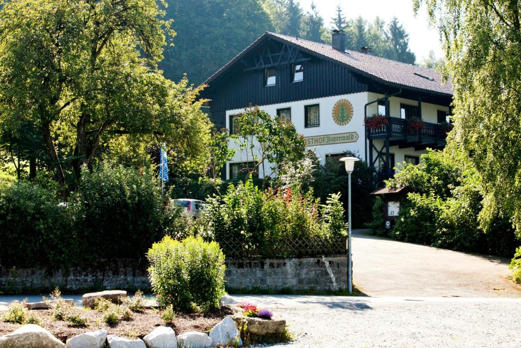Grafling巴伐利亚森林酒店的一座黑色和白色的大建筑,设有花园