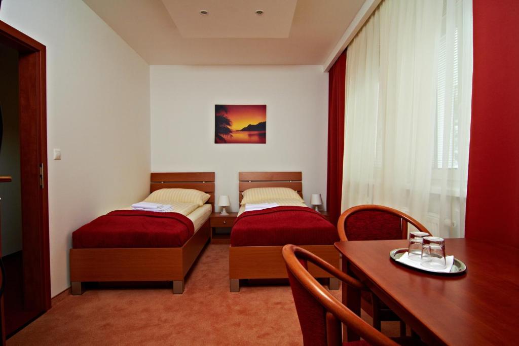 布拉迪斯拉发多奈特膳食公寓的带两张床和一张桌子的房间以及一间用餐室
