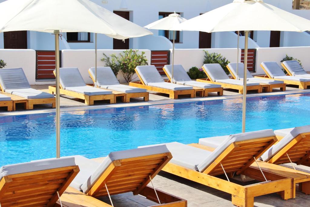 费拉以费斯托斯别墅酒店的一个带躺椅和遮阳伞的游泳池