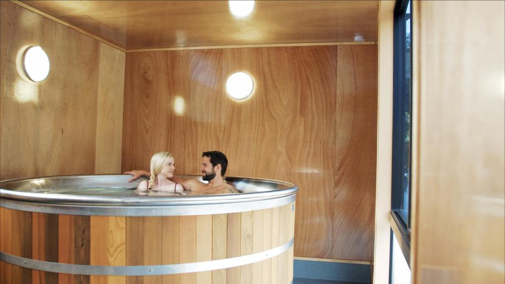 皇后镇Apartments at Queenstown TOP 10 Holiday Park的男人和女人在浴缸里和狗一起洗澡