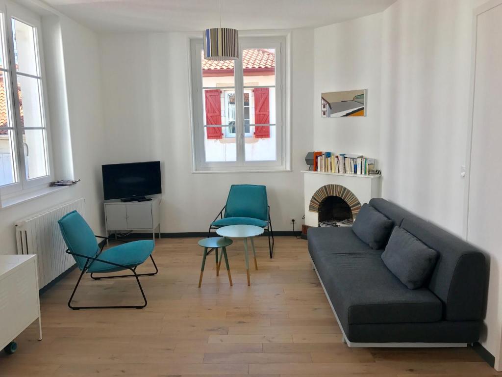 圣让-德吕兹Loquin的客厅配有沙发、椅子和壁炉