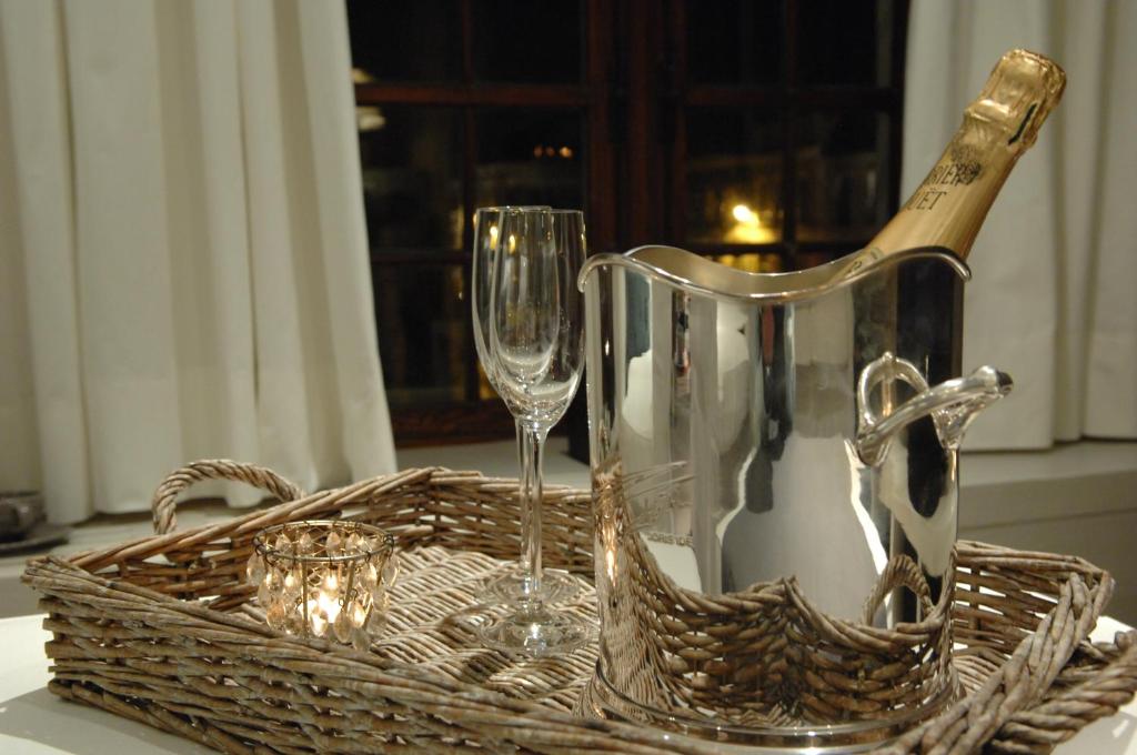 根特沃特兹住宿加早餐酒店的桌子上装有葡萄酒瓶和玻璃杯的篮子