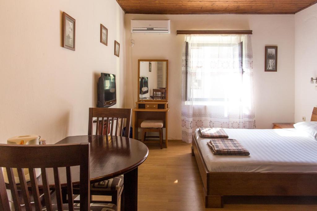 拉法洛维奇Apartments Kole的一间卧室配有一张床铺和一张桌子,还有一间用餐室