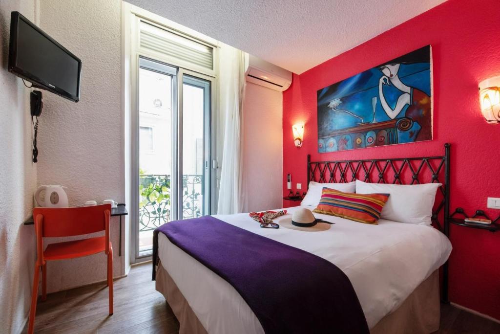 戛纳布里默戛纳酒店的红色卧室,配有带帽子的床