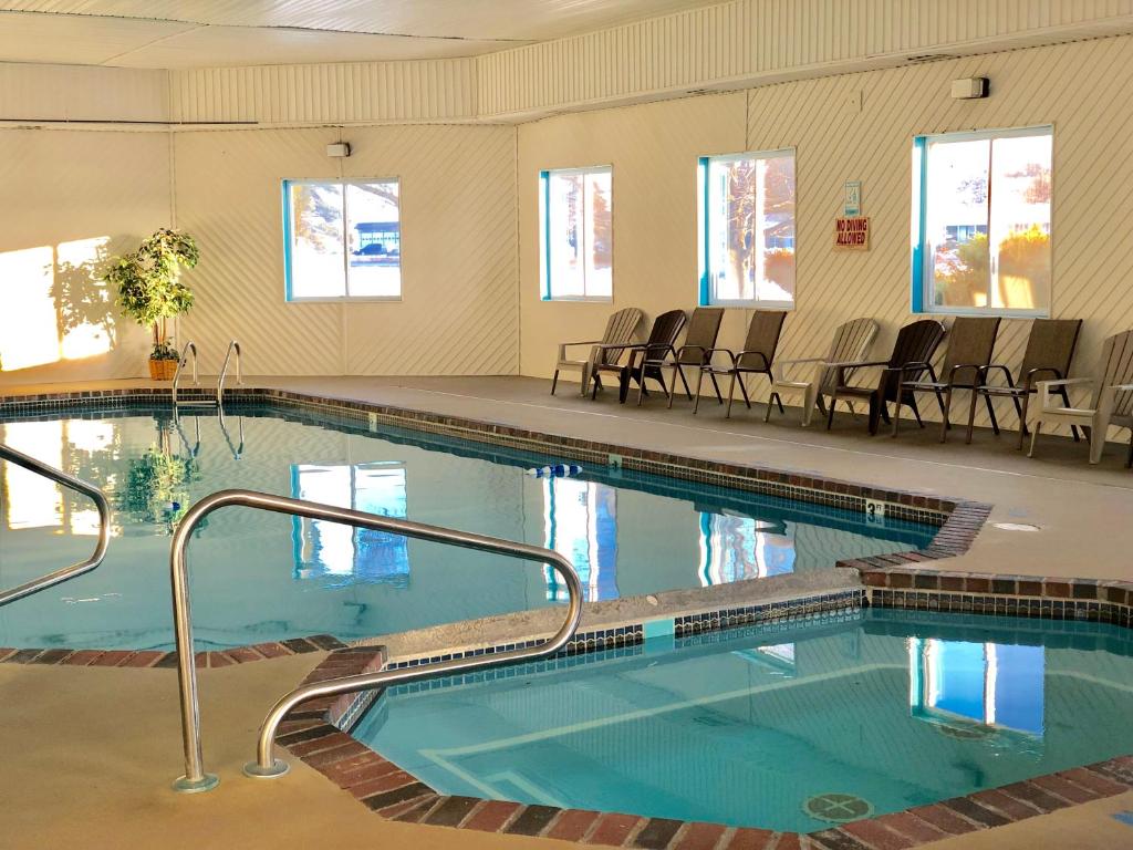 埃斯卡诺巴埃斯卡诺巴速8酒店的大楼内带椅子的大型游泳池