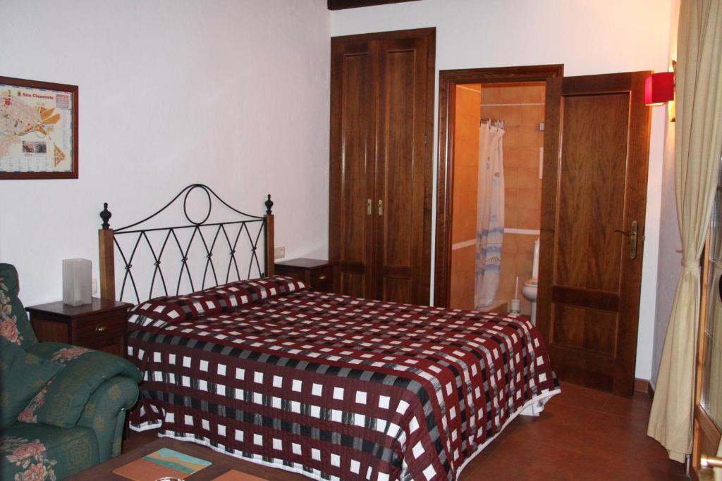 圣克莱门特Hostal Nuevo Milán I的一间卧室配有一张带棕色和白色毯子的床