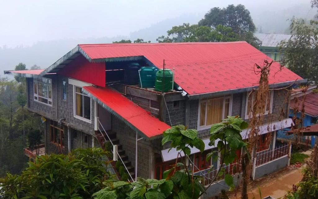 TakdāhVamoose Cosynook Homestay的山上有红色屋顶的房子