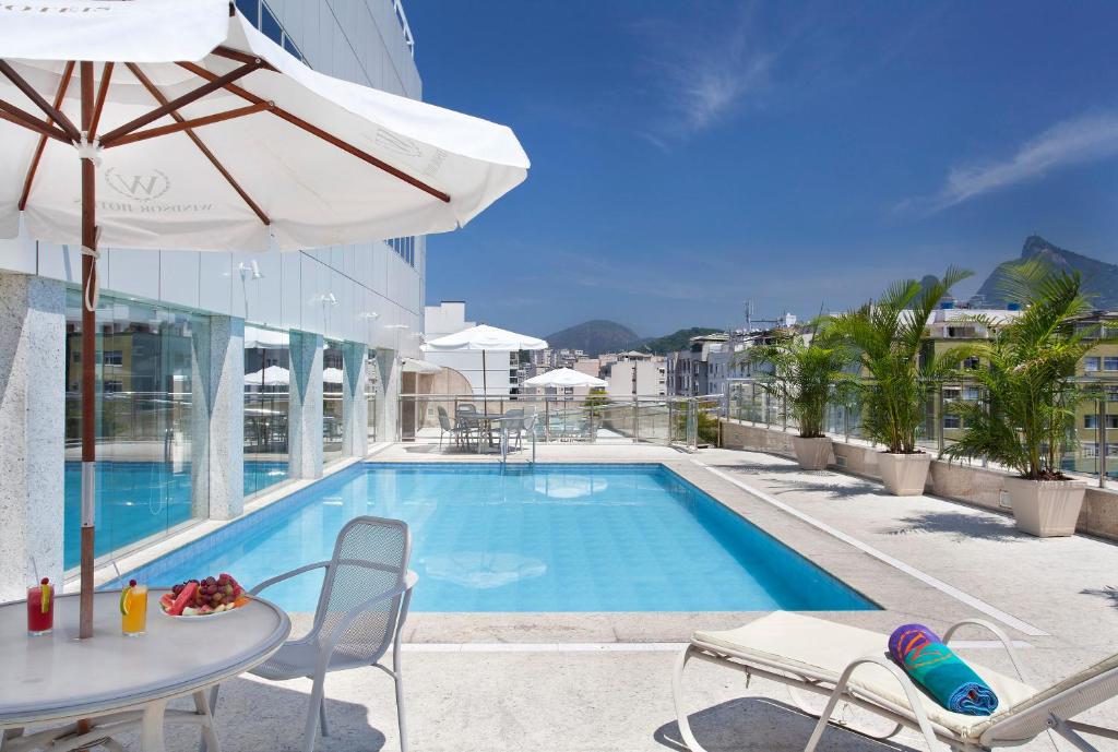 里约热内卢Windsor Florida Hotel的一个带桌椅和遮阳伞的游泳池