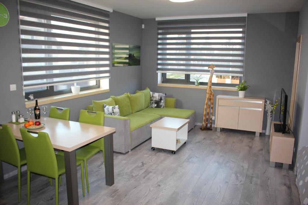 布拉格Apartments Severka的客厅配有绿色沙发和桌子