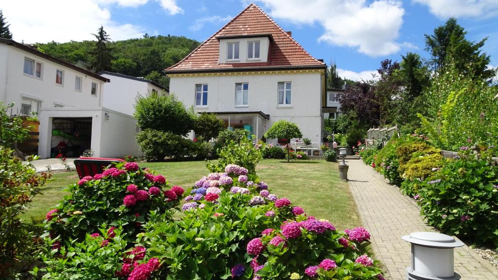 巴特哈尔茨堡Ferienwohnung Loma的一座房子,前面有一个种着鲜花的花园