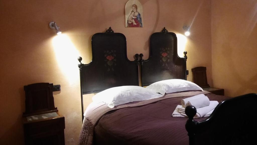 MontecarottoAgriturismo il Bacucco的一间卧室配有一张大床和两个床头板