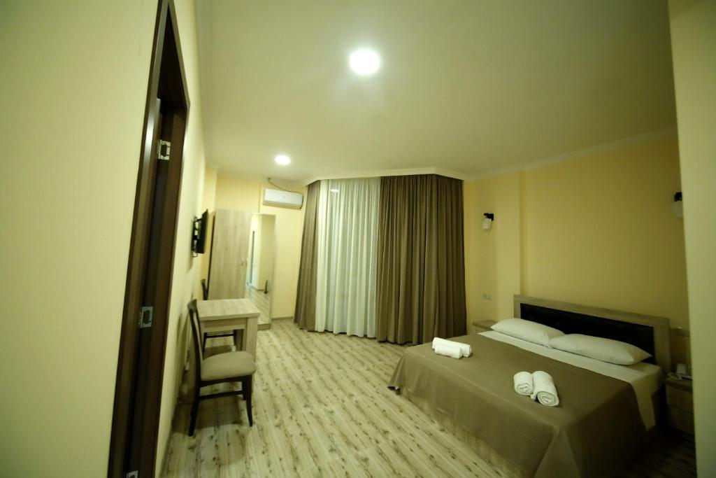 库塔伊西Hotel Comfort的配有一张床和一把椅子的酒店客房