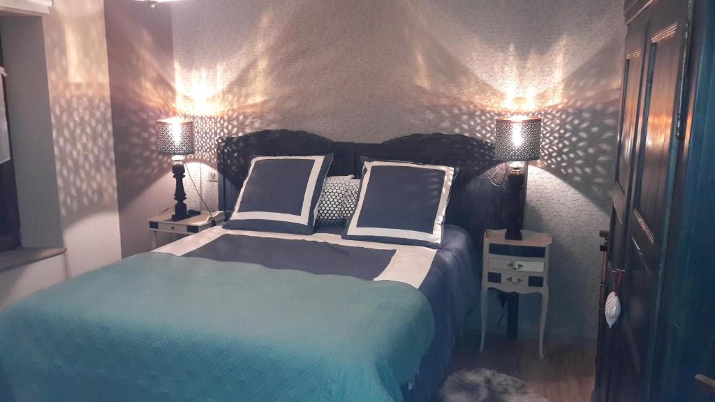 利克维Au fil de l'écriture - Appartement sur la Route des Vins à riquewihr的一间卧室配有一张带两个枕头和两个灯的床。