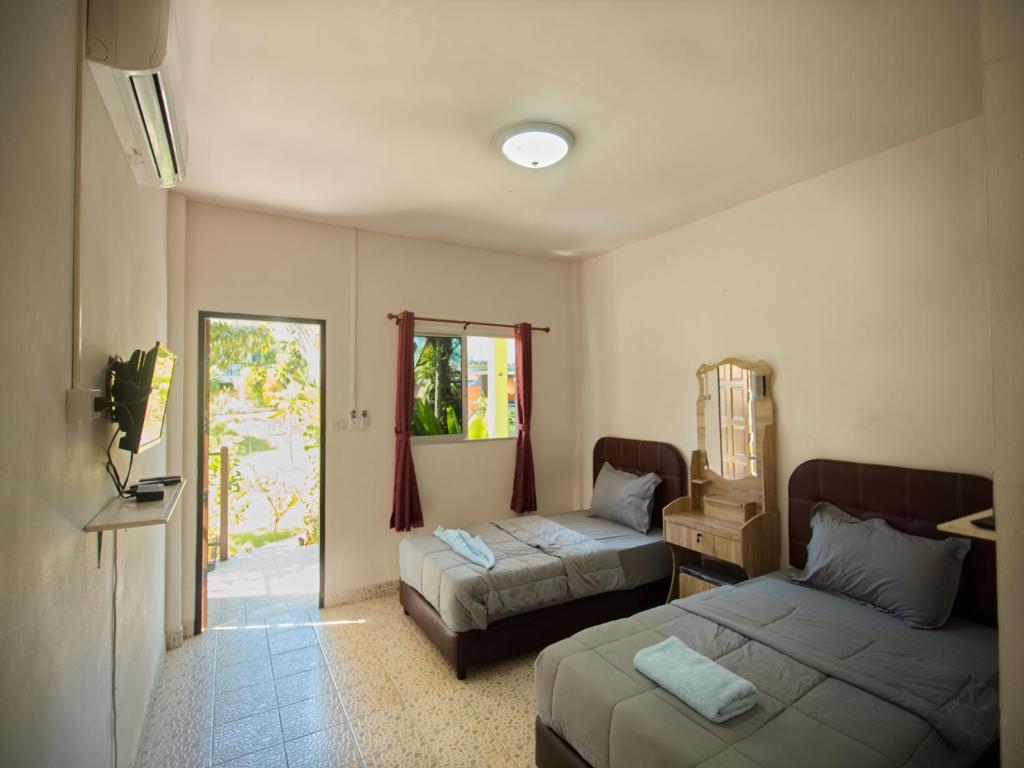 麦岛海景度假村的酒店客房设有两张床和窗户。