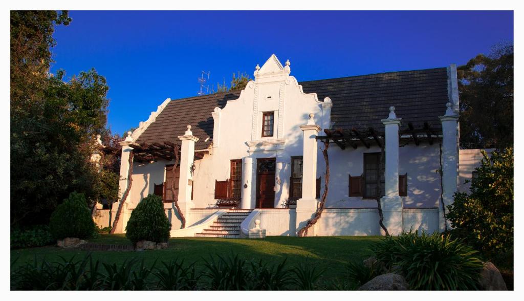 斯泰伦博斯Mooiplaas Wine Estate的蓝色天空的白色房子