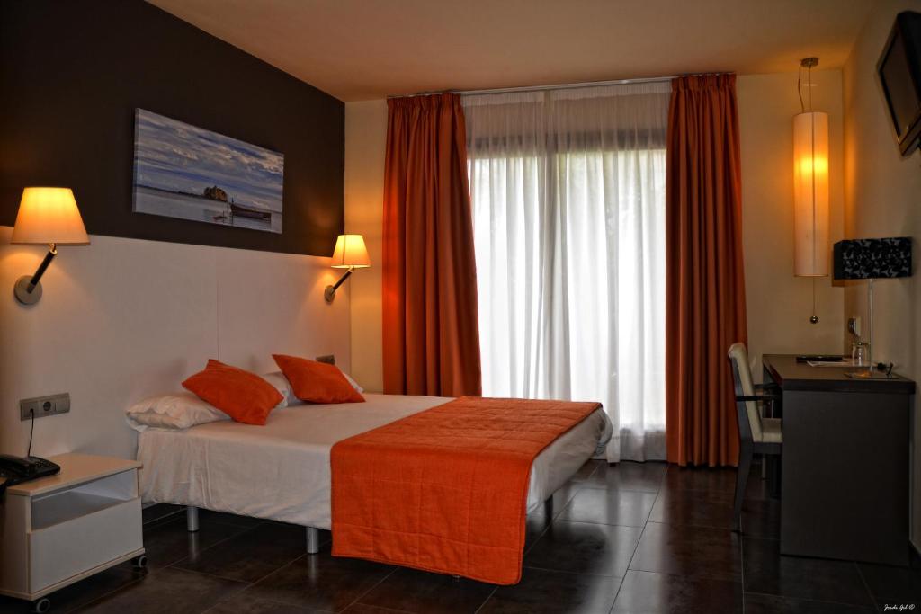 圣卡洛斯拉腊皮塔坎巴蒂斯特酒店的酒店客房,配有一张带橙色毯子的床