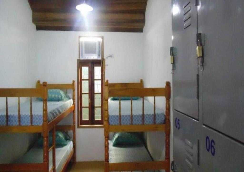 帕拉蒂Livina Hostel的客房设有两张双层床和一台冰箱。