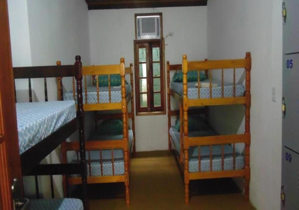 帕拉蒂Livina Hostel的有三张双层床和一扇窗户的房间
