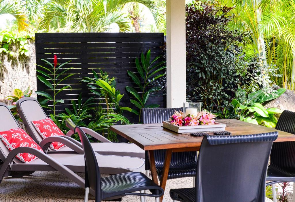 拉罗汤加马卡亚拉巴尔姆斯酒店的庭院配有木桌和椅子