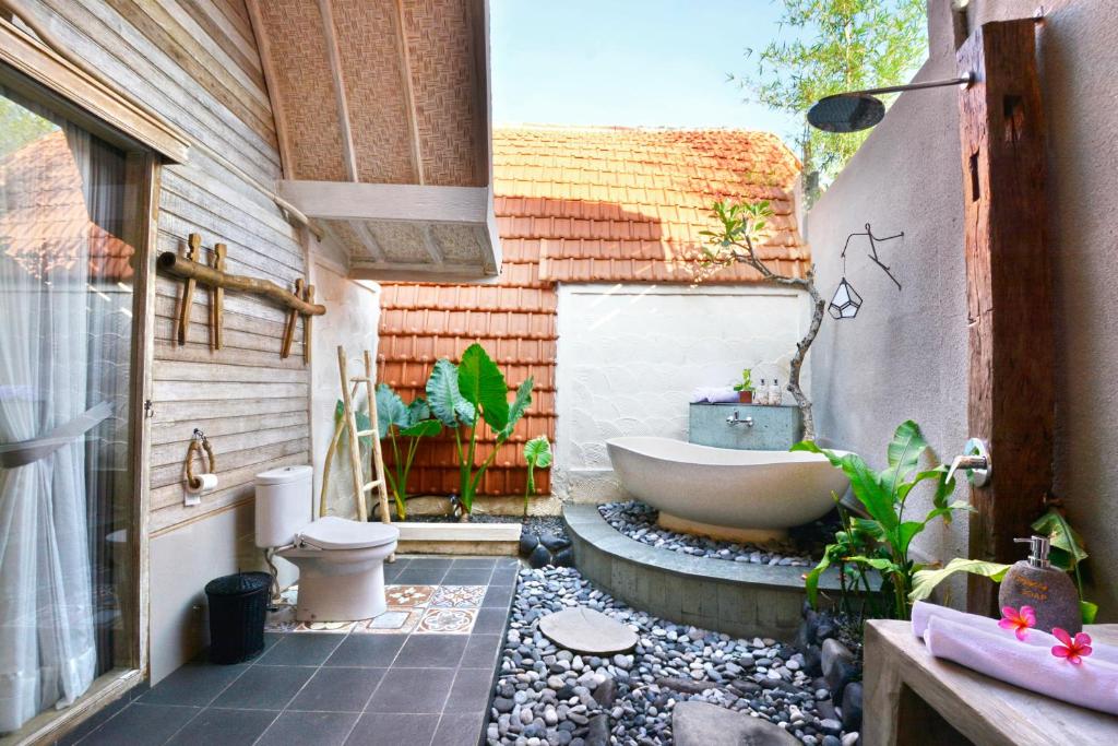 珀尼达岛Kompyang Cottage的带浴缸、卫生间和盥洗盆的浴室