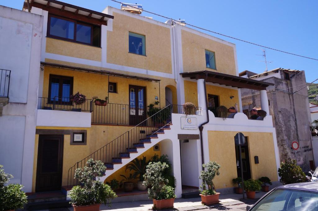利帕里卡萨马塔拉佐酒店的黄色和白色的建筑,有楼梯和植物