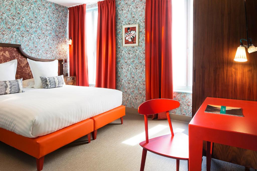 巴黎快乐文化约瑟芬酒店的酒店客房,设有一张床铺和一张红色的书桌
