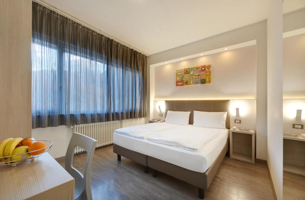 博尔扎诺阿里斯顿酒店的酒店客房配有一张床铺和一张桌子。