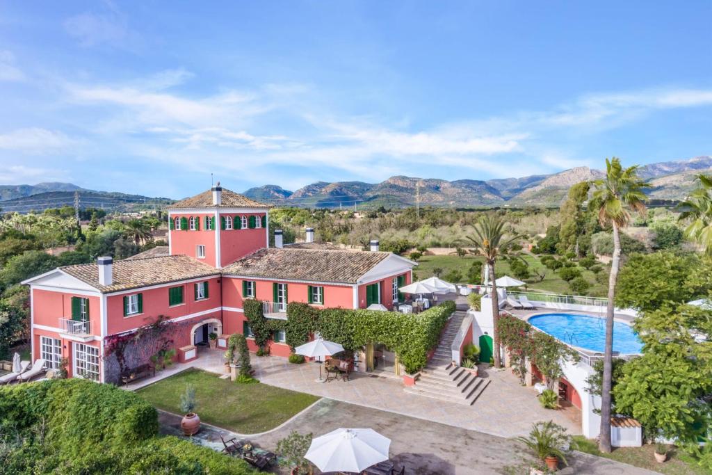 Son SardinaFincahotel Los Naranjos的享有粉红色房子空中美景,设有游泳池