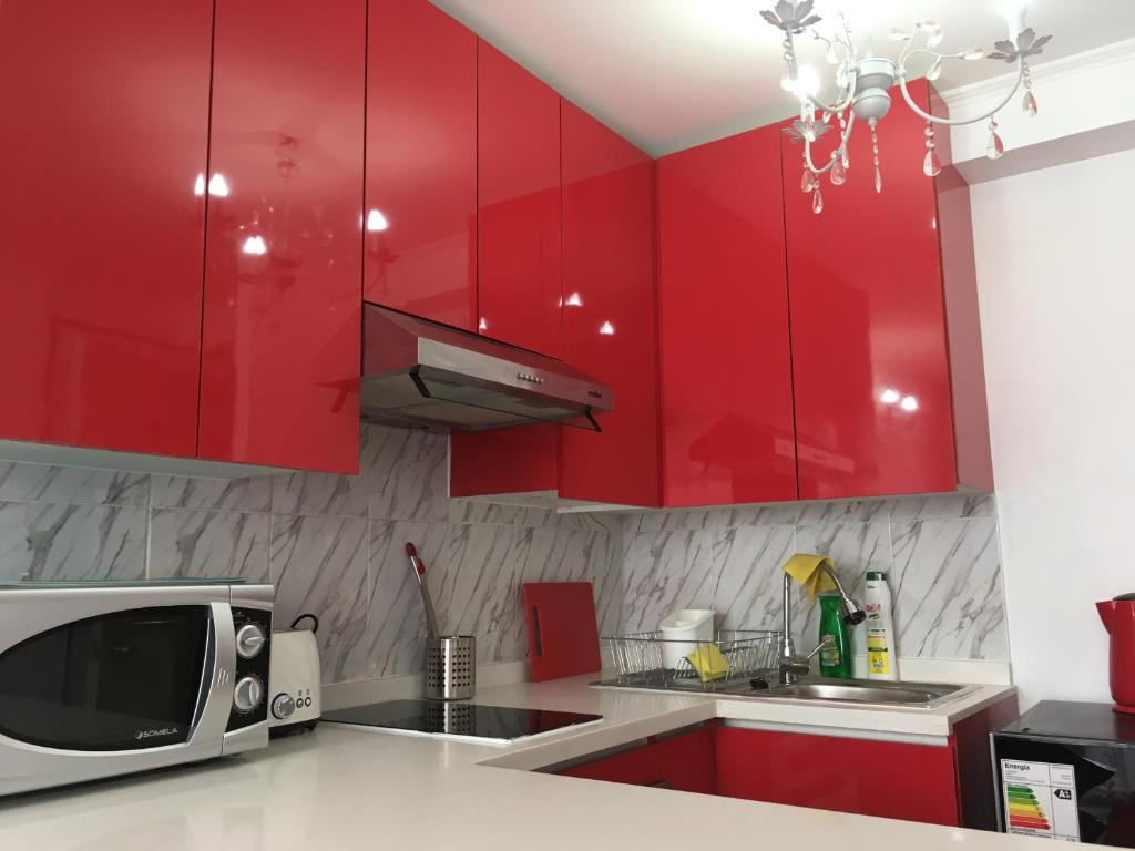 圣地亚哥Depto Metro Cal y Canto的一间带红色橱柜和微波炉的厨房
