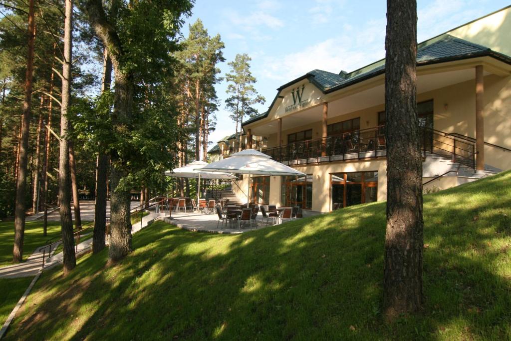 Gawrych Ruda维格拉米河畔酒店的前面有草坪和树木的房子