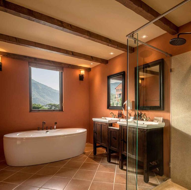 慕斯Toscana Hotel La Casetta的浴室配有两个盥洗盆和浴缸。