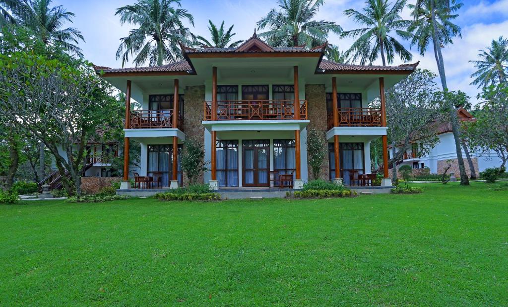 芒希Mangsit Suites by Holiday Resort Lombok的前面有绿色草坪的房子