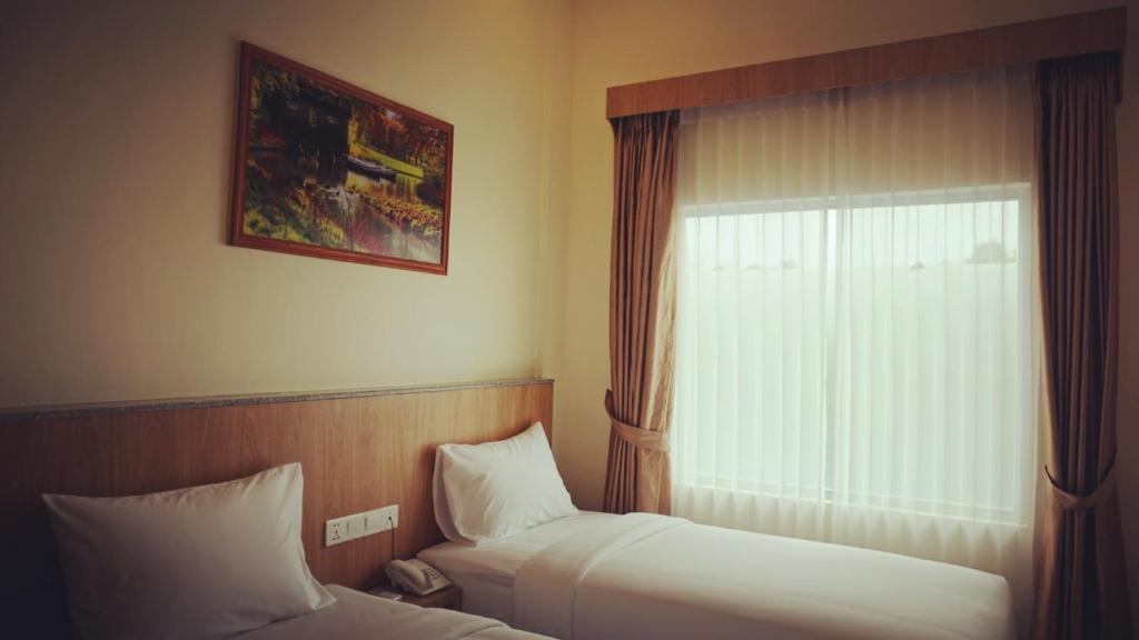 丹戎槟榔Bintan Lumba Lumba Inn Hotel的酒店客房设有两张床和窗户。