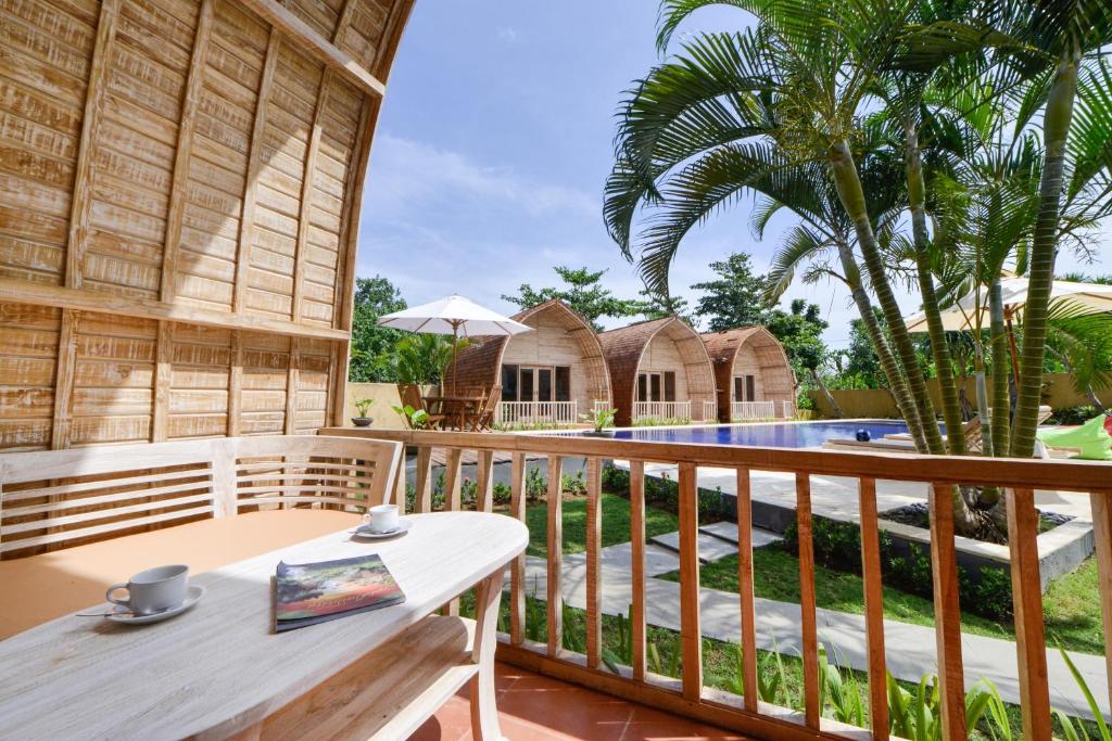 坎古Villa Del Mar Canggu的一个带桌子和游泳池的木制阳台