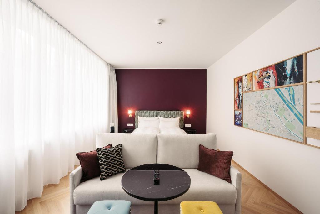 维也纳Hotel Schani Salon的客厅配有沙发和1张床
