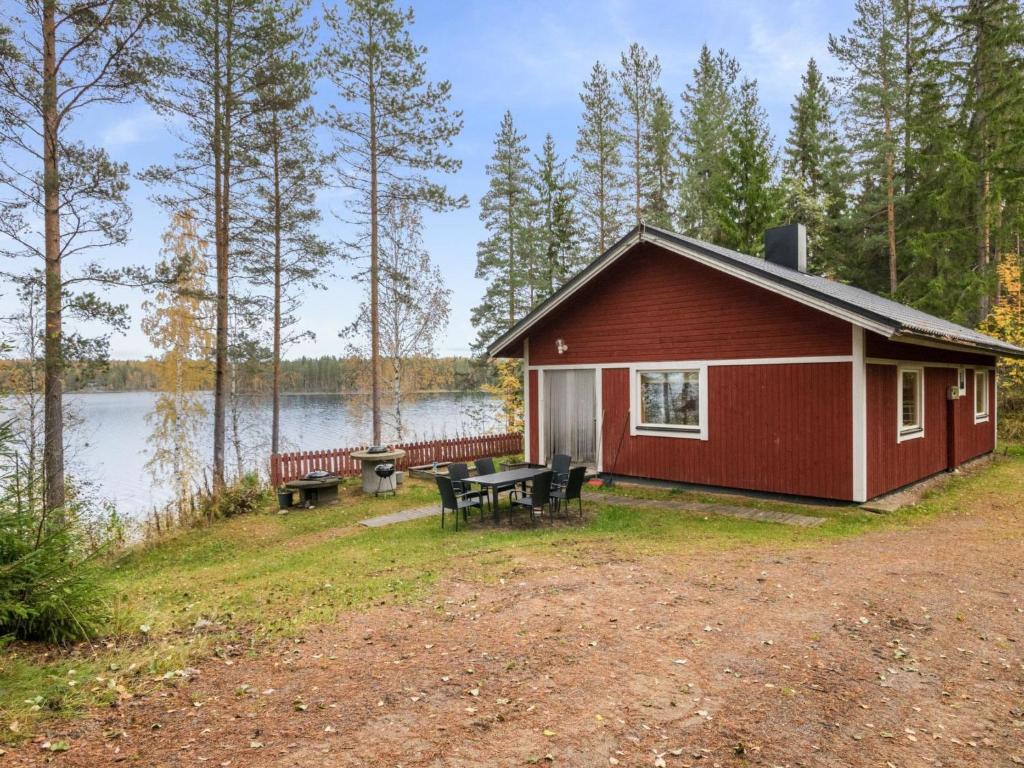 VuoriniemiHoliday Home Aamuntorkku by Interhome的湖畔红色小屋,配有野餐桌