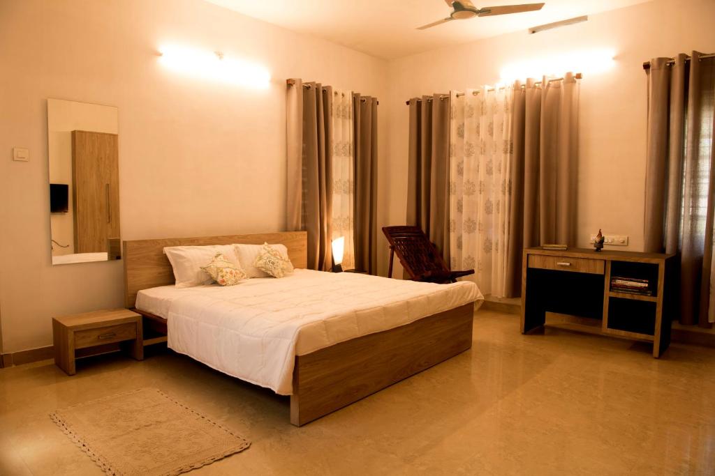 德里久尔Gloria Homestay ,Thrissur的一间卧室配有一张床、一张桌子和一面镜子