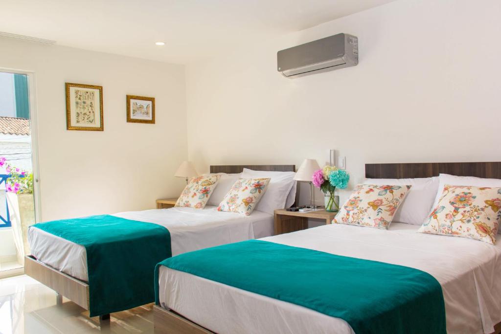 卡利Hotel Avanti Chipichape的一间卧室配有两张带绿色和白色床单的床