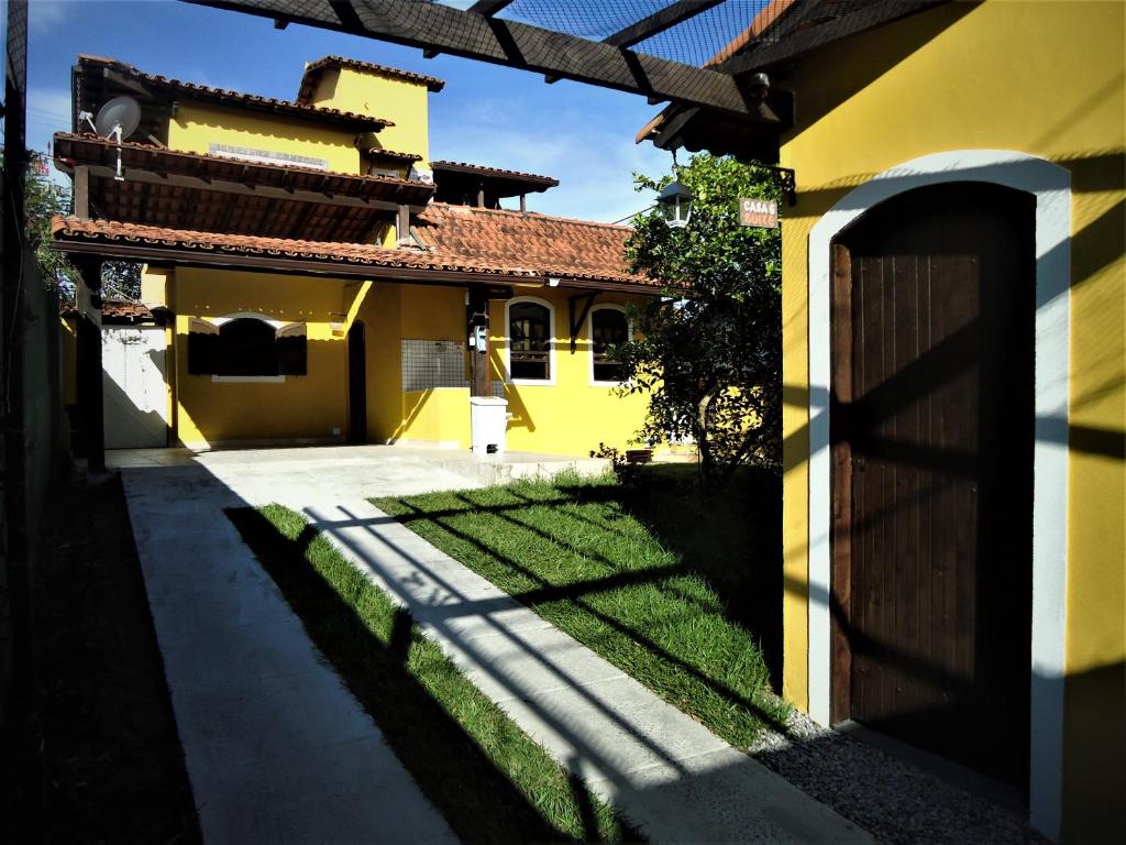 卡波布里奥Vila do Sossego的黄色的房子,有门和院子