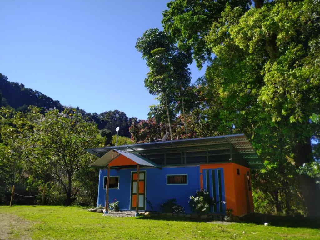 圣赫拉多德多塔Hospedaje Casa Monge的田野里的一个蓝色和橙色的小房子